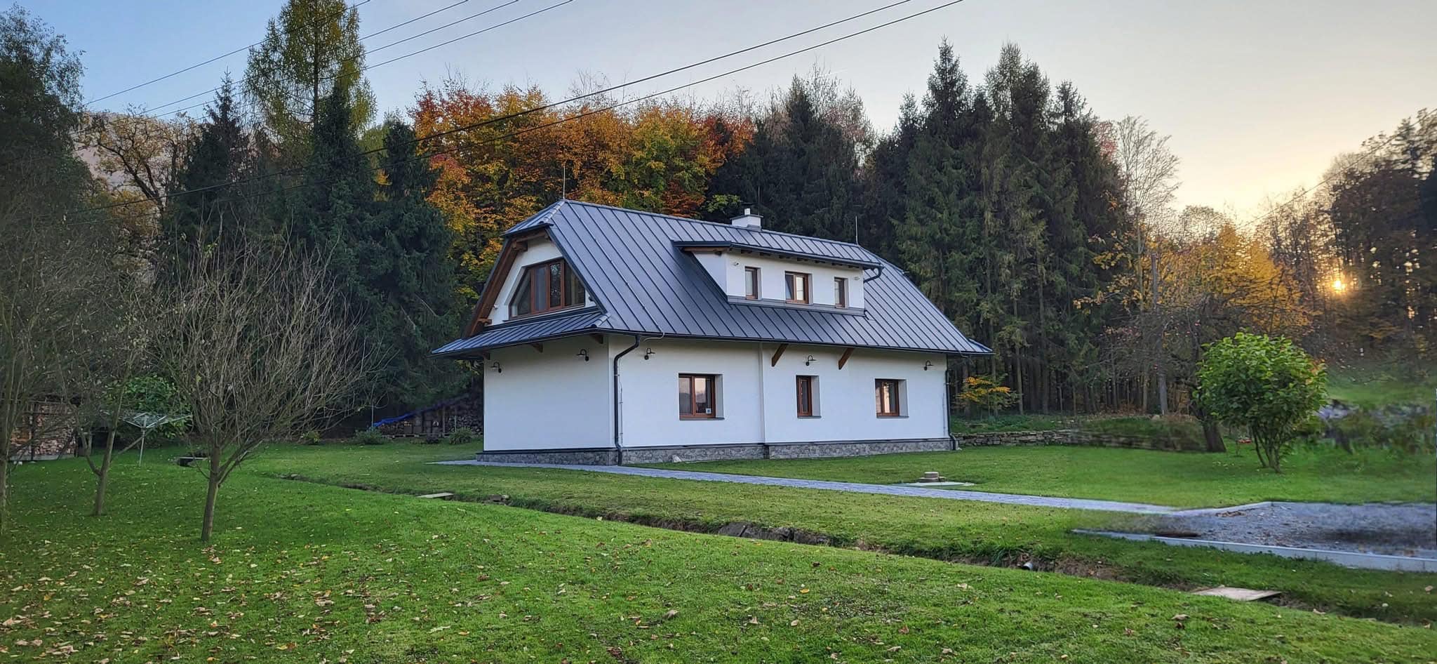 Chalupa Hukvaldy — dokončený dům při západu slunce v lese